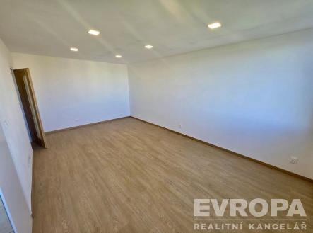 Prostorný obývací pokoj, parketová podlaha, moderní vestavěná světla, neutrální barvy stěn, ideální pro vlastní návrh interiéru | Pronájem bytu, 1+kk, 32 m²