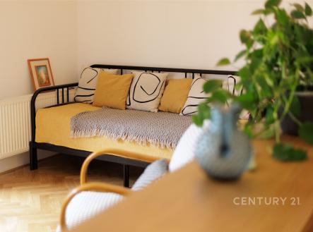 Světlý obývací pokoj s parketovou podlahou, moderním nábytkem a velkými okny vytváří útulnou atmosféru pro relaxaci a odpočinek. | Pronájem bytu, 2+kk, 57 m²