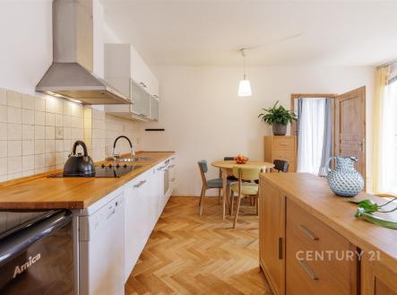 Světlá kuchyň s parketovou podlahou, moderní spotřebiče, dřevěná pracovní deska, velká okna poskytující dostatek přirozeného světla. | Pronájem bytu, 2+kk, 57 m²