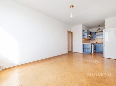 Světlý obývací pokoj s parketovou podlahou, moderní kuchyní a velkými okny, které poskytují dostatek přirozeného světla. | Prodej bytu, 2+kk, 41 m²