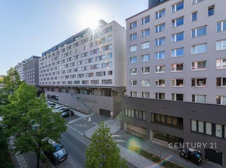 Moderní bytový dům s velkými okny, světlá fasáda a prostorná parkovací plocha, nachází se v klidné části města. | Pronájem bytu, 2+kk, 52 m²