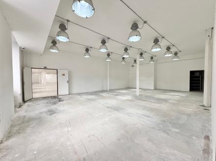 Prostorná průmyslová hala s betonovou podlahou, moderní osvětlení, vysoké stropy, ideální pro skladovací nebo výrobní účely. | Pronájem - obchodní prostor, 200 m²