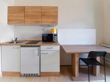 kuchyně s deformace, myčka, dřevěná podlaha, dřez, a mikrovlnná trouba | Pronájem bytu, 1+1, 23 m²