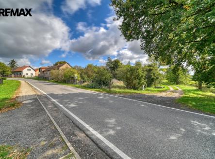 pohled na pozemek z hlavní příjezdové komunikace | Prodej - pozemek pro bydlení, 974 m²