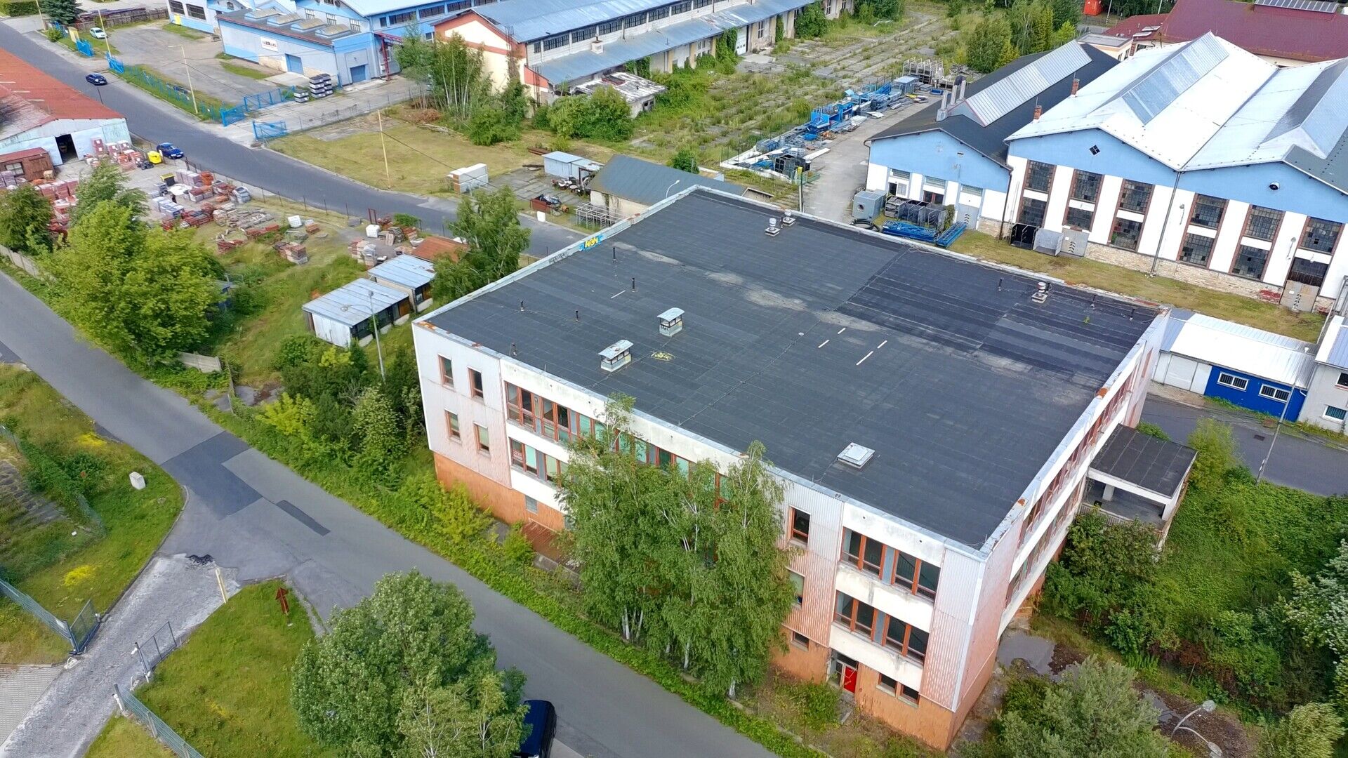 Třípodlažní průmyslový objekt o podlahové ploše cca 3.000 m2 s okolními pozemky