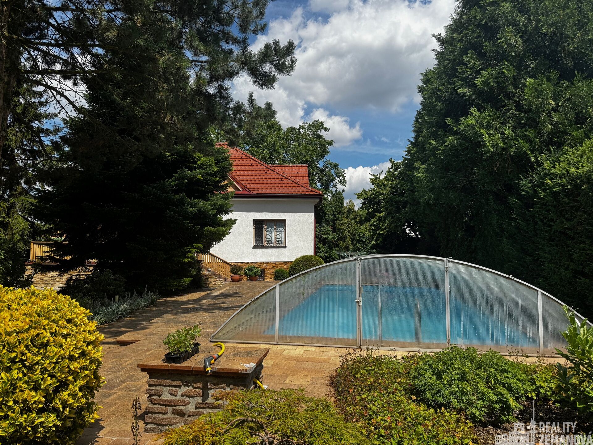 pohled od letní kuchyně k bazénu a domu