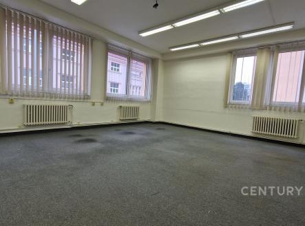 Prostorná kancelář s kobercovou podlahou, velkými okny a vertikálními žaluziemi, vhodná pro moderní pracovní prostředí. | Pronájem - kanceláře, 43 m²