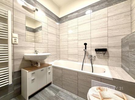 Moderní koupelna s dlažbou, vanou a umyvadlem, skříňka pod umyvadlem, koupelnový radiátor. Světlá rekonstrukce ve stylovém provedení. | Pronájem bytu, 1+kk, 28 m²