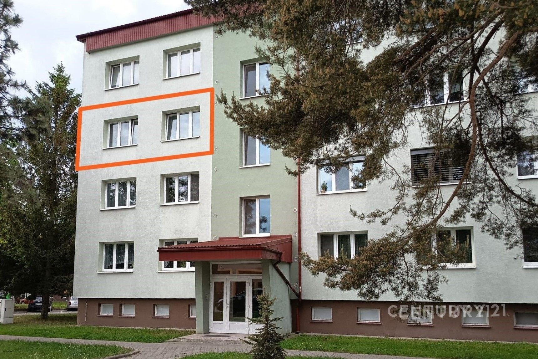 Podlaží bytového domu s bílou fasádou a červenou stříškou, plastová okna, udržovaná předzahrádka, klidná lokalita.