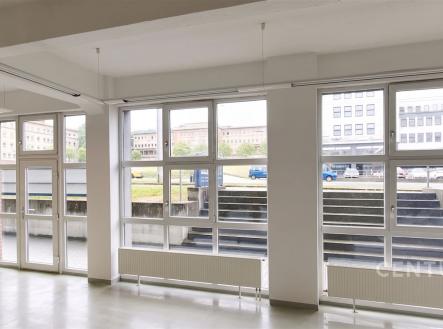 Světlá kancelářská místnost s velkými okny, moderní dlažbou a bílými stěnami, ideální pro kreativní pracovní prostředí. | Pronájem - obchodní prostor, 162 m²