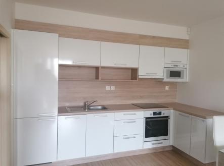 kuchyně s bílé skříně, digestoř, dřevěná podlaha, trouba, a dřez | Pronájem bytu, 2+kk, 57 m²