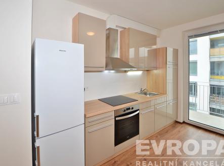 kuchyně s lednička, trouba, digestoř, dřevěná podlaha, a sporák | Pronájem bytu, 1+kk, 34 m²