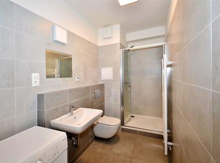 vana s stěna dlaždic, zrcadlo, kachličková podlaha, dřez, a sprcha | Pronájem bytu, 1+kk, 34 m²