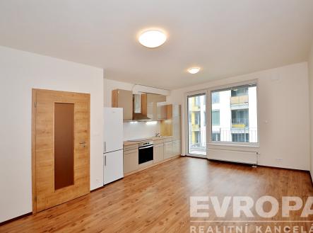 kuchyně s lednička, radiátor, digestoř, dřevěná podlaha, a přirozené světlo | Pronájem bytu, 1+kk, 34 m²