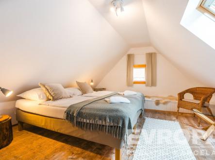 pokoj / ložnice s dřevěná podlaha, světlík, přirozené světlo, a klenutý strop | Prodej - dům/vila, 260 m²