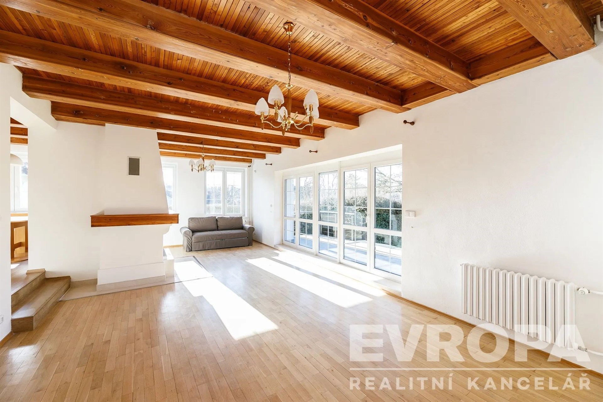 prázdná místnost s přirozené světlo, trámový strop, radiátor, a dřevěná podlaha