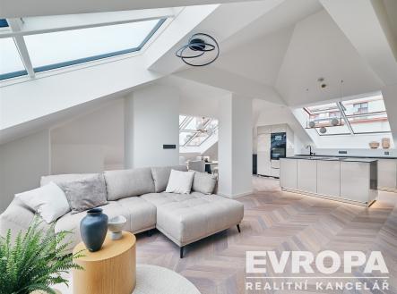 Světlý obývací pokoj s parketovou podlahou, velkými střešními okny a moderním interiérem. Propojený kuchyňský kout s ostrůvkem a designovým osvětlením | Pronájem bytu, atypický, 120 m²