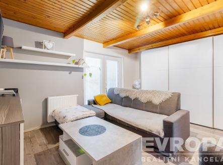 Světlý obývací pokoj s dřevěnými stropy, moderní vestavěné skříně, parketová podlaha, útulné vybavení, a elegantní nábytek. | Pronájem - chata/rekreační objekt, 73 m²