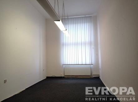 Prázdná kancelář s velkým oknem, moderní zářivkové osvětlení, neutrální koberec, ideální pro rekonstrukci nebo přizpůsobení. | Pronájem - skladovací prostor, 30 m²