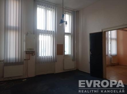 Prázdný kancelářský prostor, vysoká okna, světlé stěny, závěsy, centrální vytápění, vhodné pro rekonstrukci, udržovaný interiér. | Pronájem - skladovací prostor, 30 m²