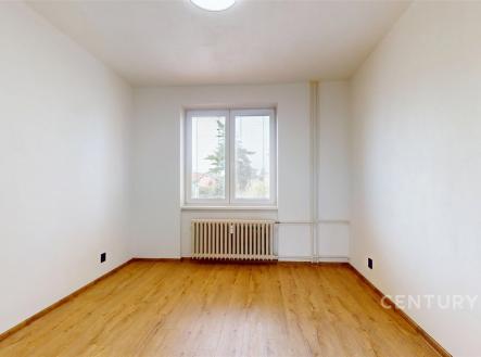 Prázdný pokoj s parketovou podlahou, světlými stěnami a velkým oknem. Radiátor pod oknem poskytuje vytápění. | Prodej bytu, 2+1, 56 m²