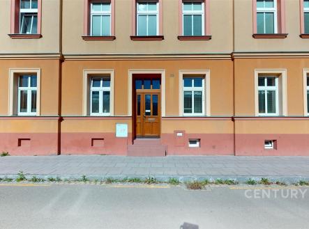 Historická fasáda bytového domu s dřevěnými dveřmi a velkými okny, udržovaná architektura a klidná lokalita poblíž centra. | Prodej bytu, 3+1, 72 m²