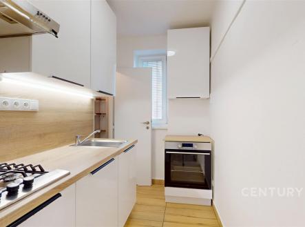 Moderní kuchyň s vestavěnými spotřebiči, dřevěnou pracovní deskou a světlými skříňkami, dlažba na podlaze, ideální pro efektivní vaření. | Prodej bytu, 3+1, 73 m²