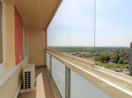 Zasklená lodžie s panoramatickým výhledem, dlažba na podlaze, moderní zasklení, ideální pro relaxaci. | Prodej bytu, 3+kk, 83 m²