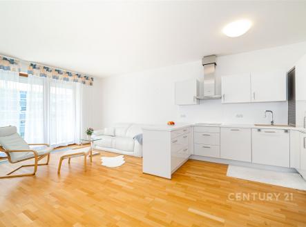 Světlý obývací pokoj s moderní kuchyní, parketová podlaha, velká okna, renovovaný interiér, bílý nábytek, otevřený prostor. | Prodej bytu, 3+kk, 105 m²