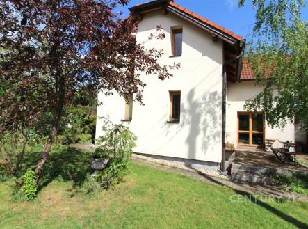 Zahrada s rodinným domem, dřevěná terasa, moderní architektura, stromy pro soukromí, světlá fasáda, zelený trávník, klidná lokalita. | Prodej - dům/vila, 168 m²
