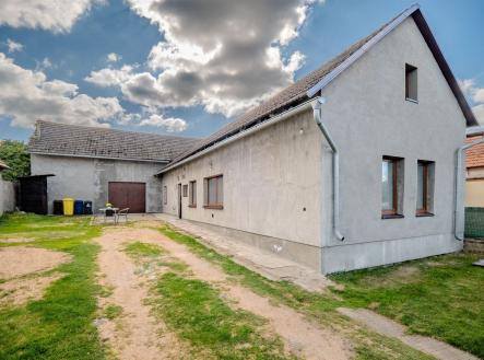 Exteriér rodinného domu s novou fasádou, štěrková příjezdová cesta, prostorný dvůr, vhodné k rekonstrukci, klidná lokalita. | Prodej - dům/vila, 71 m²