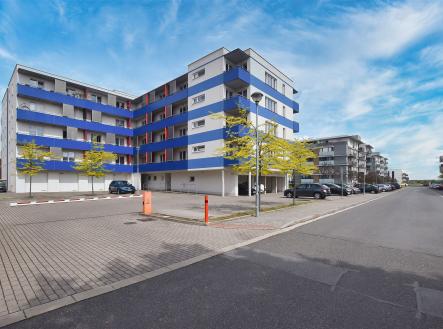 Moderní bytový dům se světlou fasádou a modrými balkony, k dispozici parkovací místa, vhodný pro rezidenční bydlení nebo investici. | Prodej bytu, 2+kk, 62 m²