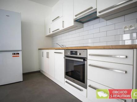 kuchyně s trouba, backsplash, bílé skříně, betonová podlaha, a lednička | Pronájem bytu, 2+kk, 56 m²