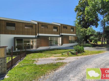 Řadový dům se dřevěným obkladem, moderní design, velká okna a terasa, nachází se v klidné ulici s okolní zelení. | Prodej - dům/vila, 298 m²