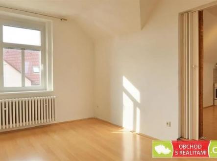 prázdná místnost s dřevěná podlaha, klenutý strop, přirozené světlo, a radiátor | Pronájem bytu, 2+kk, 43 m²