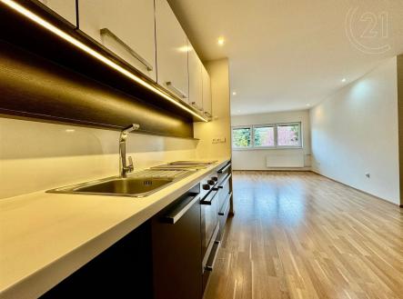 kuchyně s dřevěná podlaha, dřez, bílé skříně, přirozené světlo, a deformace | Pronájem bytu, 2+kk, 55 m²