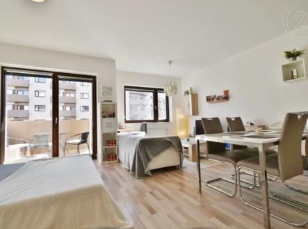pokoj / ložnice s přirozené světlo, pozoruhodný lustr, a dřevěná podlaha | Pronájem bytu, 1+kk, 39 m²