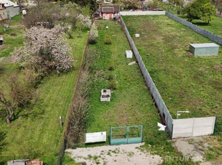 Prostorná zahrada s ovocnými stromy a plotem, ideální pro stavbu rodinného domu. Rovný terén s přístupovou cestou, klidná lokalita. | Prodej - pozemek pro bydlení, 1 057 m²