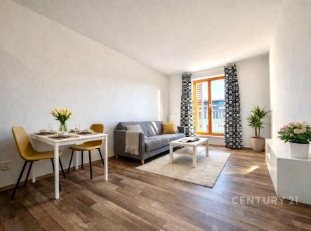 Světlý obývací pokoj s parketovou podlahou, velkými okny a moderním zařízením, poskytuje útulné prostředí k relaxaci a zábavě. | Pronájem bytu, 2+kk, 48 m²