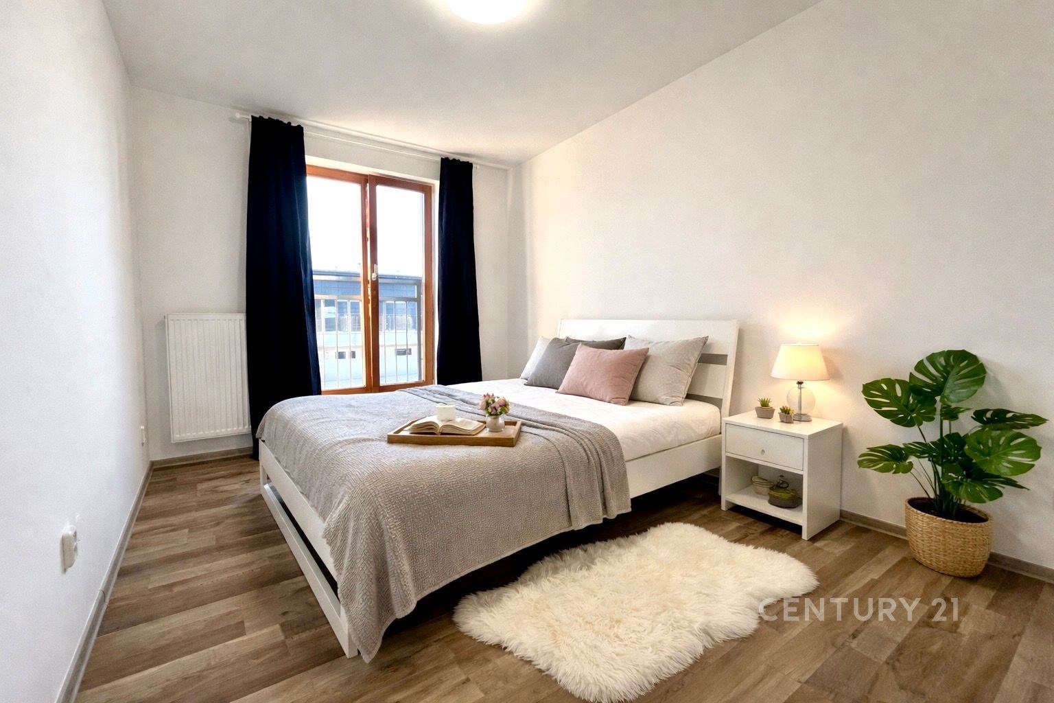 Prostorná ložnice s parketovou podlahou, velkými okny a moderním nábytkem, vytváří světlý prostor pro relaxaci.