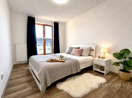 Prostorná ložnice s parketovou podlahou, velkými okny a moderním nábytkem, vytváří světlý prostor pro relaxaci. | Pronájem bytu, 2+kk, 48 m²