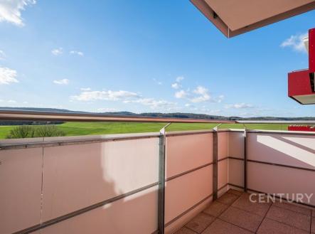 Balkón s dlážděnou podlahou nabízí panoramatický výhled na krajinu, moderní zábradlí zajišťuje bezpečnost a stylově dotváří prostor. | Pronájem bytu, 1+kk, 34 m²