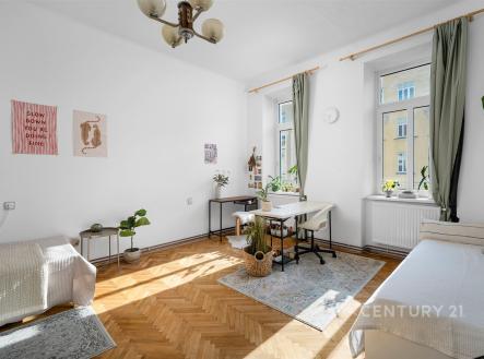 Světlý obývací pokoj s parketovou podlahou, velká okna poskytují dostatek přirozeného světla, moderní dekorace a výhled do ulice | Prodej bytu, 3+1, 87 m²