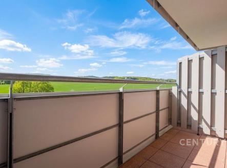 Balkon s výhledem na krajinu, dlažba, moderní zábradlí, světlý prostor, ideální pro relaxaci v přírodním prostředí. | Pronájem bytu, 1+kk, 34 m²