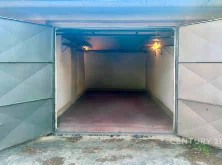 Praktická garáž s betonovou podlahou, kovovými dveřmi a elektrickým osvětlením, vhodná pro bezpečné parkování a uložení vozidla. | Pronájem - malý objekt/garáž