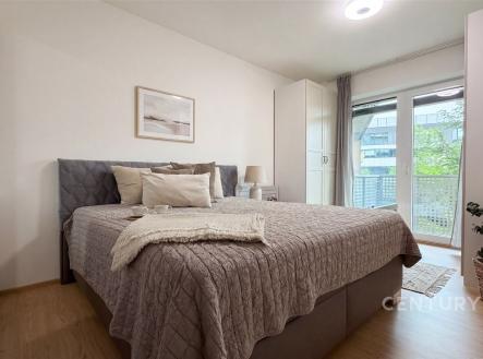 Světlá ložnice s moderním stylem, parketová podlaha, velká okna vedoucí na balkon, vestavěné skříně poskytující dostatek úložného prostoru. | Prodej bytu, 2+kk, 62 m²