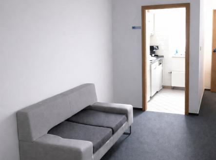 Šedá chodba s kobercem, moderní sedačka, vstup do světlé kuchyně s dlažbou, minimalismus, rekonstruovaný prostor v bytě | Pronájem - kanceláře, 350 m²