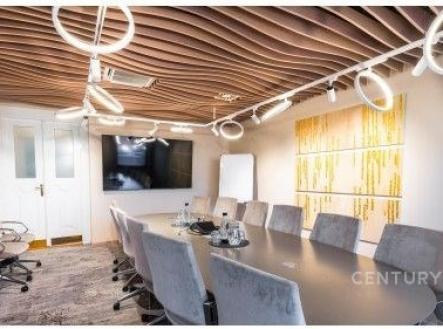 Moderní zasedací místnost s velkým oválným stolem, designovým stropem a kruhovým osvětlením, vybavena moderní technologií a pohodlnými židlemi. | Pronájem - obchodní prostor, 503 m²