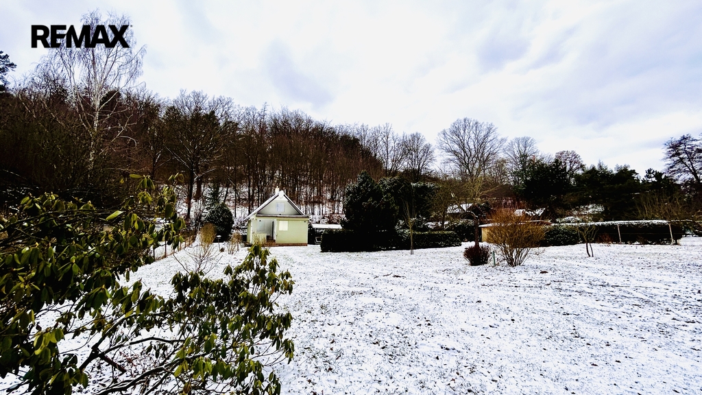 Pohled na chatu a zahradu od vjezdové brány