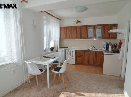 pohled na kuchyňský kout a jídelní stůl se třemi židlemi | Pronájem bytu, 1+kk, 37 m²